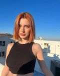 Anadolu genç Rus escort, modern bir ortamda çekici bir kıyafetle poz veriyor, sarışın ve tutkulu escort hizmetlerini temsil ediyor.
